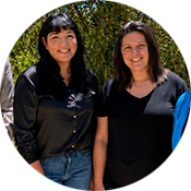 Paula Pacheco, left, and Mia Abonce, right, wear black shirts standing in front of a tree