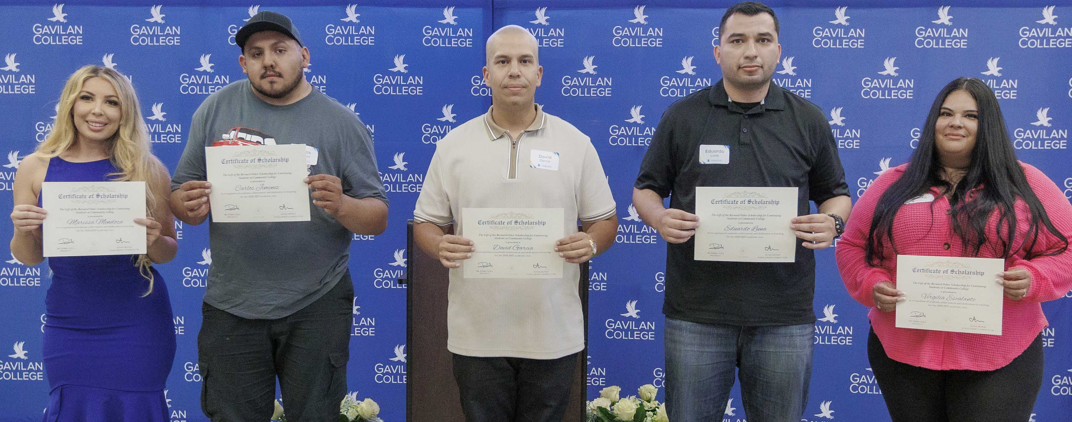 Five scholarship recipients pose for a photo in front of a Gavilan College backdrop, each holding a scholarship certificate.
