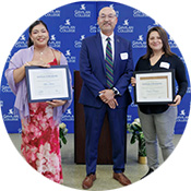 Two students stand on either side of Superintendent President, Dr. Pedro Avila, each holding a framed scholarship certificate, with a blue scholarship event backdrop behind them.